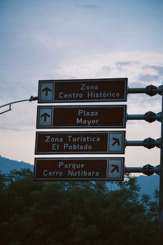 Street signs in Medellín point to Zona Centro Histórico and El Poblado.